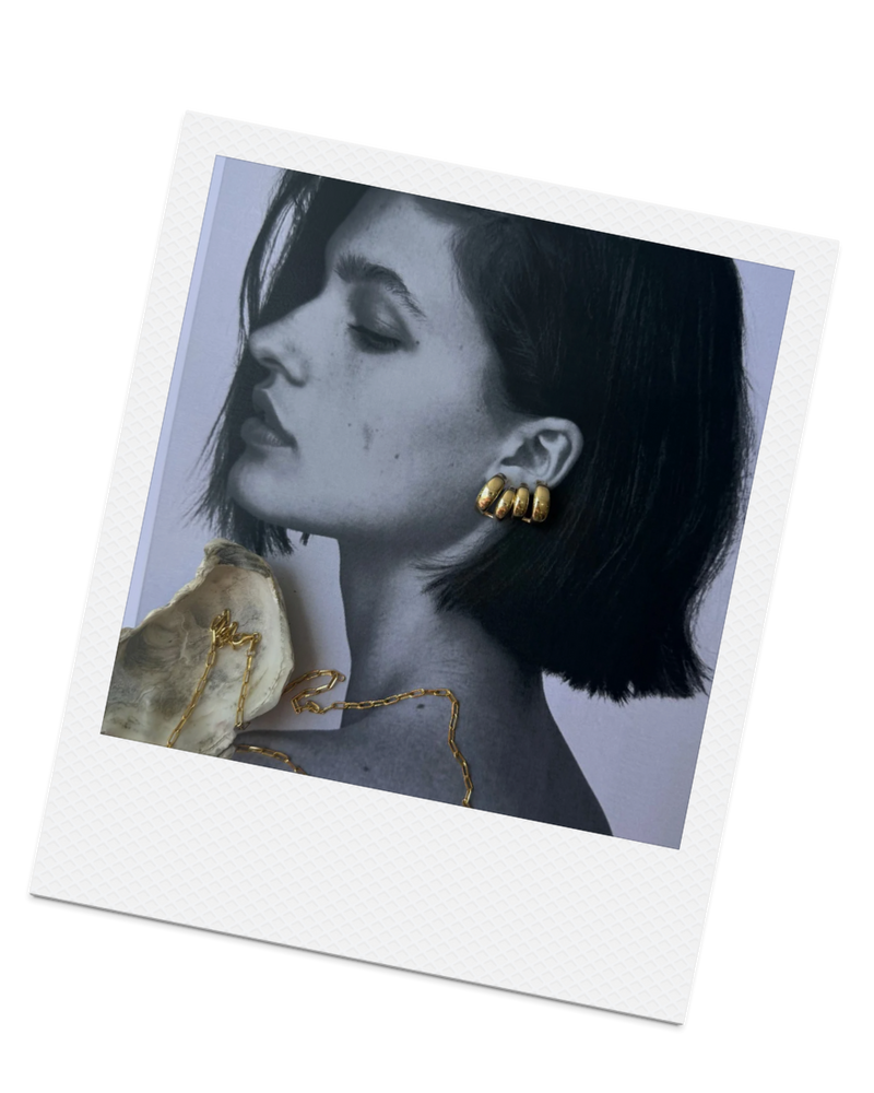 Polaroid-style photo of a woman wearing earrings on a white background